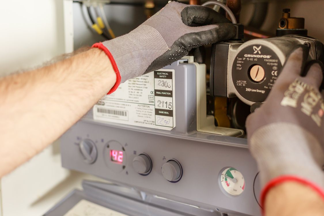 Technician servicing a boiler heating system
